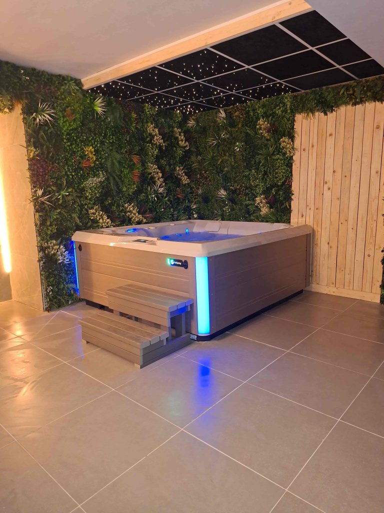 Jacuzzi in wellnessruimte met groene plantenwand en sterrenplafond