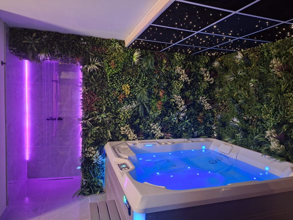 Jacuzzi met regendouche en groene wand bij Carokri Wellness
